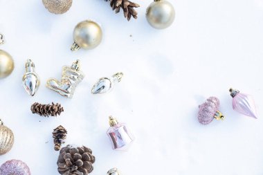 Kışın Noel 'i, kar kurdeleli Noel baloları, kış tatili konsepti. Noel Altın Topları, Çam ve Kar Taneleri Kar Arkaplanındaki Süslemeler