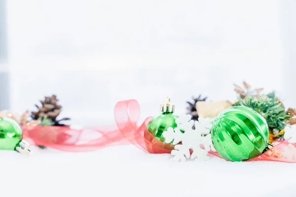 Christmas of  winter - Christmas balls with ribbon on snow, Winter holidays concept. Christmas green balls, golden balls, pine And Snowflakes decorations In Snow Background