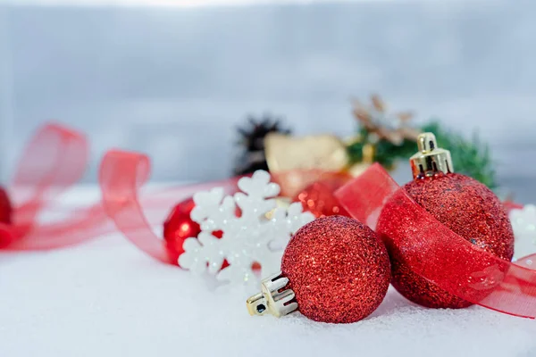 Christmas of  winter - Christmas balls with ribbon on snow, Winter holidays concept. Christmas red balls, golden balls, pine And Snowflakes decorations In Snow Background