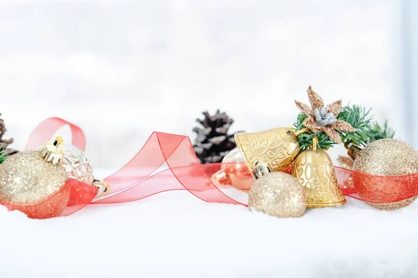 Christmas of  winter - Christmas balls with ribbon on snow, Winter holidays concept. Christmas red balls, golden balls, pine And Snowflakes decorations In Snow Background