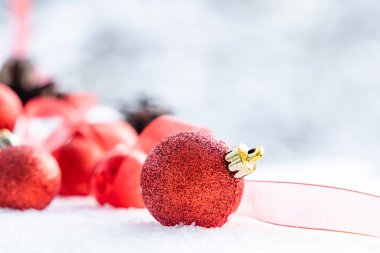 Kışın Noel 'i, kar kurdeleli Noel baloları, kış tatili konsepti. Noel kırmızı topları, altın toplar, çam ve kar taneleri kar altında süslemeler