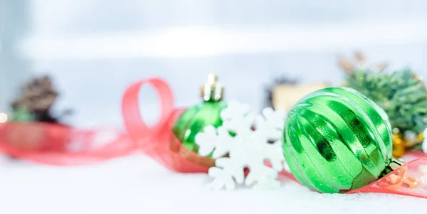 Christmas of  winter - Christmas balls with ribbon on snow, Winter holidays concept. Christmas green balls, golden balls, pine And Snowflakes decorations In Snow Background