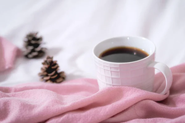 coffee cup with a scarf and red plaid on the white table, top view, space for text.