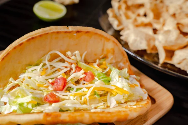 stock image Closeup of a taco salad in a tortilla shell with chips. plate with taco, nachos chips and tomato dip