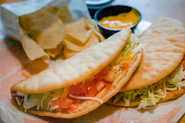 stock image Closeup of a taco salad in a tortilla shell with chips. plate with taco, nachos chips and tomato dip