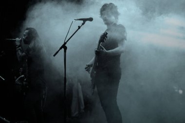 Sahnede elektro gitarla müzik çalan bir adam.