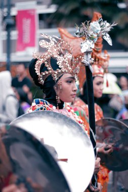 Geleneksel giysiler içinde bir kadın bir karnavalda kalabalığın ortasında.