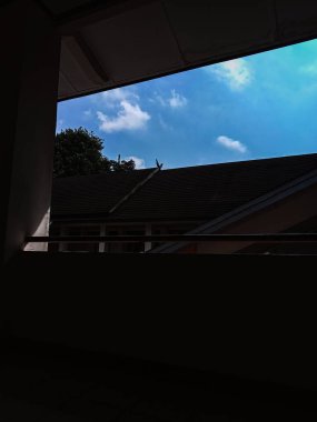 dilihat dari çatı, bangunan terlihat gelap dengan langit biru