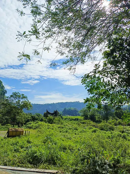 stock image Nature Lanscape traditional Minangkabau house surrounded by beautiful green hills and bright blue skies