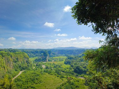 expanse of green hills and blue skies during the day, beautiful views from the top of the name Puncak Taruko Bukittinggi, Indonesia clipart