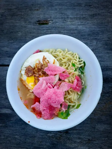 stock image Instant noodles in a bowl topped with egg and crackers