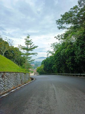 Tepedeki asfalt yolda, sabah güzel manzaralı.