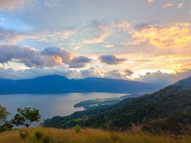 Beautiful sunset on Lake Singkarak from the top of the Aua Sarumpun peak, West Sumatra clipart