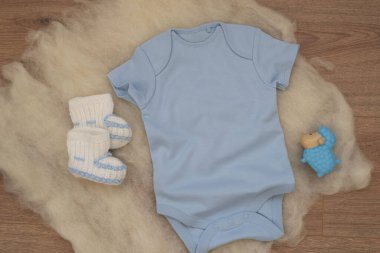 Ahşap arka planda mavi bebek tulumu modeli. Boş bebek kıyafetleri maket gibi. Düz yatmış stok fotoğrafı.