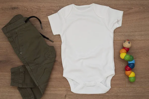 Burla Traje Bebé Blanco Sobre Fondo Madera Con Pantalones Juguete Fotos De Stock