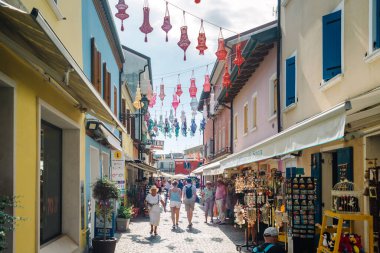 Caorle Venice, İtalya - 4 Eylül 2023: tarihi merkezde dükkanları olan insanlar sokakta yürüyor