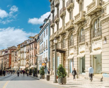 Granada, Endülüs, İspanya - 2 Mart 2025: Güneşli bir günde Granada şehir merkezinde kalabalık bir cadde