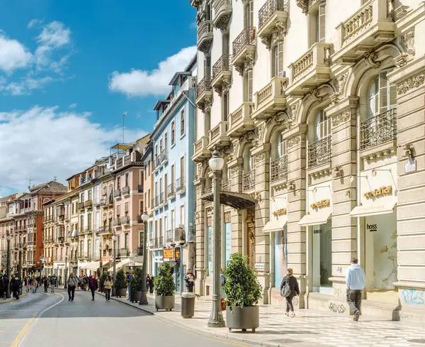 Granada, Endülüs, İspanya - 2 Mart 2025: Güneşli bir günde Granada şehir merkezinde kalabalık bir cadde