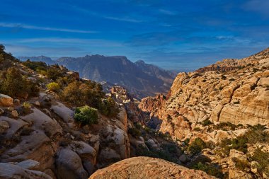 Ürdün gün batımı manzarası. Dana Biyosfer Rezervi 'nde turuncu akşamıyla Rocky Dağı, Jorda. Arabistan 'da seyahat. Dana Doğa 'da Taşlar ve Vadi, Vahşi Yaşam.