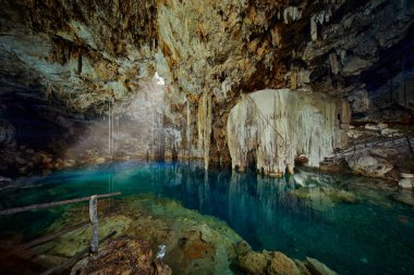 Cenote Dzitnup Xkeken, cave south of Valladolid. Landscape in Yucatan, Mexico. Green blue water lake in cave, light in the hole. Travel in Mexico.