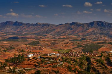 Madagaskar manzarası. Tarlaları ve köyleri olan bir dağ. Afrika 'da doğa yıkımı, Madagaskar' da sıcak mevsim. Evleri olan turuncu tarlalar. Afrika 'daki Madagaskar tepelerine bakın.. 