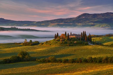 Tuscany 'de manzara, Siana ve Pienza yakınlarında, İtalya' da gün doğumu sabahı. Tuscany 'deki tepecikli çayır manzaralı güzel bir sabah ışığında, İtalya. Doğada sisli sabah.