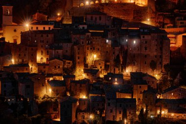 Sorano, Toskana, İtalya. Uçurumun kenarında küçük bir ortaçağ kasabası. Gece şehir ışıkları. Kayadaki köy, Avrupa 'da seyahat. İtalya 'da gece şehir ışıkları