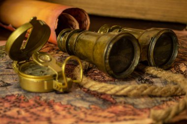 Macera masasında antik macera parşömeni geçmişi. Dürbün, parşömen, ip ve pusula masanın üstünde..