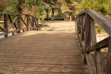 Construction of wooden bridge and protection railing in artificial lake.