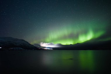 Kuzey ışıkları dağlarda gölün üzerinde