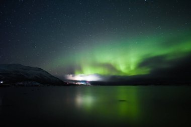 Kuzey ışıkları dağlarda gölün üzerinde