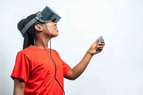 beautiful african lady with eye wear device- black woman enjoying virtual reality in a studio