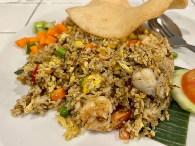 Nasi Goreng ya da Çin deniz ürünleri kızarmış pilav karidesli tavuk yumurtası ve karides krakeriyle karıştırılmış.