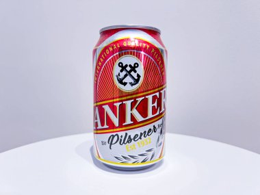 Jakarta, Endonezya - 22 Ekim 2024: Bir kutu Anker Pilsener birası. Kutu öncelikle gümüş kaplama ve alttaki kırmızı renkte. ANKER markası özellikle altın harflerle gösterilir.