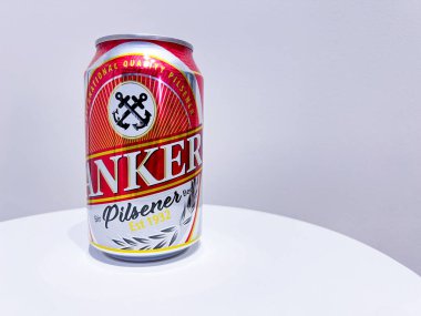 Jakarta, Endonezya - 22 Ekim 2024: Bir kutu Anker Pilsener birası. Kutu öncelikle gümüş kaplama ve alttaki kırmızı renkte. ANKER markası özellikle altın harflerle gösterilir.