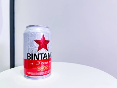 Jakarta, Endonezya - 22 Ekim 2024: bir kutu Bintang birası. Bintang taze ve ferahlatıcı tadı ile tanınan popüler bir Endonezya bira markasıdır. Teneke kutu beyaz ve kırmızı arkaplanlı