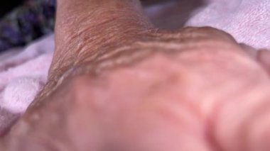 Yaşlı eller kırışıklıklarla kapanıyor.