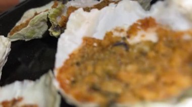 Tasty scallops cooking on the table ready to eat in their shells