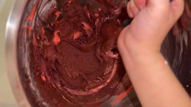 Chocolate is mixed in the metal bowl of the mixer