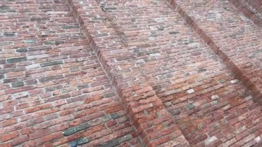 Kırmızı tuğlalardan yaratılmış antik sütunlarla dolu duvar