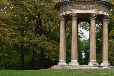 Parktaki ağaçların arasında eski bir bina.