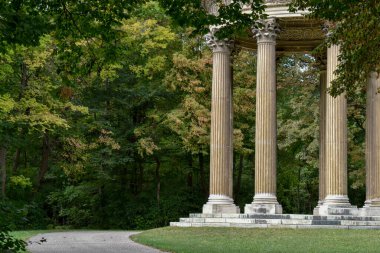 Parktaki ağaçların arasında eski bir bina.