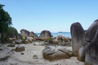 Güzel Rocky Sahili. Endonezya Belitung Adası 'ndaki tüm güzel plajlar büyük granit taşlarla süslenmiştir..