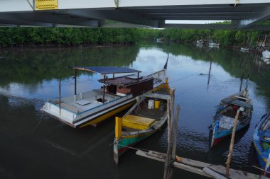 Balıkçı teknesi. Balıkçılar, Endonezya 'nın Belitung Adası' ndaki Kubu Nehri Balıkçılık Limanı 'na demir atıp teknelerini park ediyorlar. Fotoğraf öğleden sonra bulutlu bir havada çekildi..