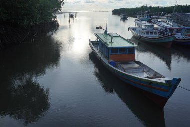 Balıkçı teknesi. Balıkçılar, Endonezya 'nın Belitung Adası' ndaki Kubu Nehri Balıkçılık Limanı 'na demir atıp teknelerini park ediyorlar. Fotoğraf öğleden sonra bulutlu bir havada çekildi..
