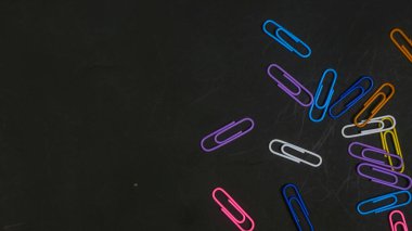 Siyah arkaplanda izole edilmiş renkli ataçlar