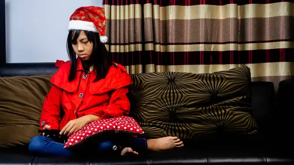 Menina Vestindo Roupa Santa Claus Sentado Sofá Preto — Fotografia de Stock