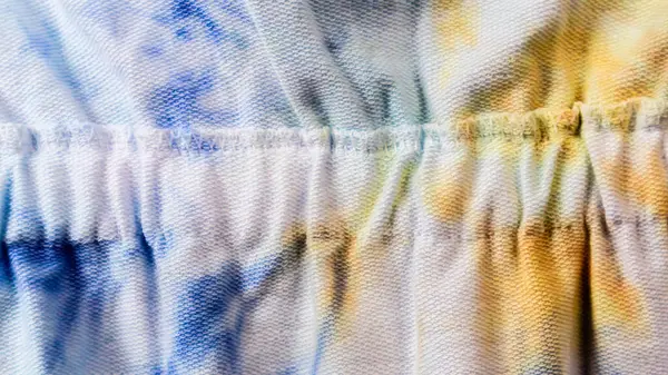 背景として黄色と青のパターンを持つ白い生地の質 — ストック写真