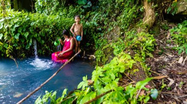 Erkek ve kız kardeşler doğal bir banyoda yıkanıyor.