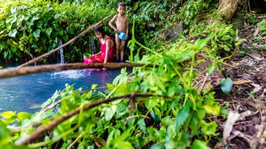 Erkek ve kız kardeşler doğal bir banyoda yıkanıyor.